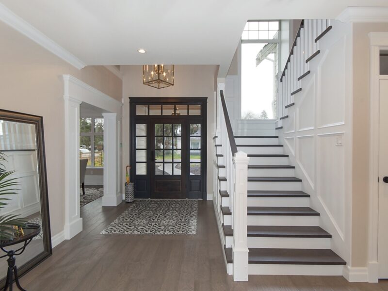 Welcoming entrance and elegant staircase, double-story staircase window adds welcome light, In-lay floor tile dresses up the entrance, door paint Benjamin Moore Wrought Iron, Maxine Whitehead design