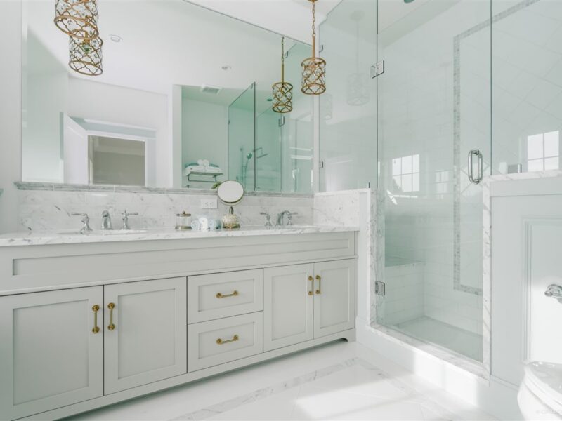 Quietly luxurious bathroom, double marble-topped vanity, elegant en-suite bathroom, large walk-in modern shower, marble tiles, pendant lights anchor the space, Maxine Whitehead design