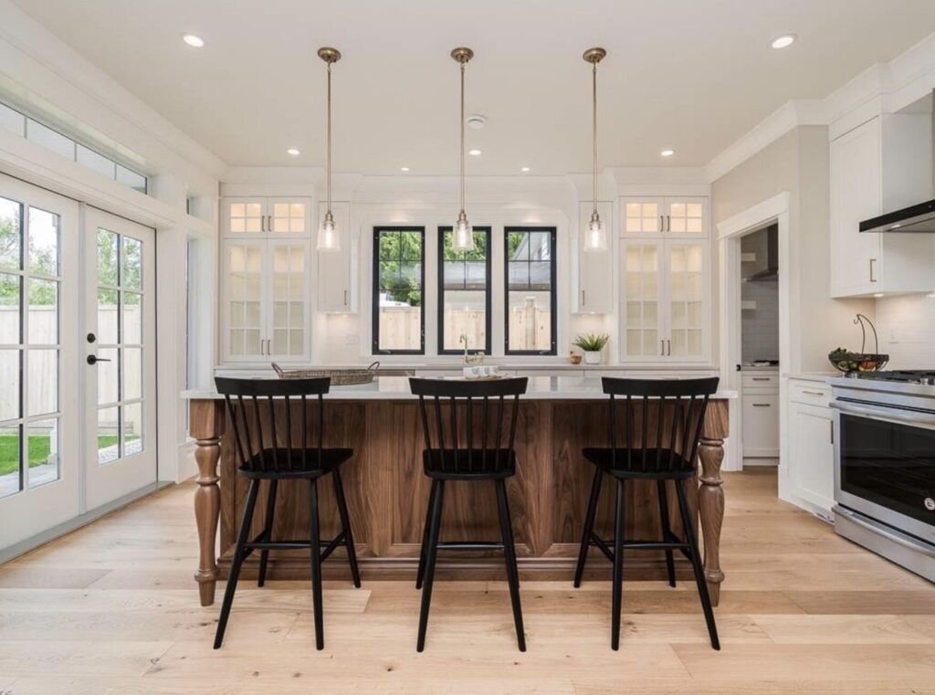 bespoke kitchen design, walnut wood kitchen cabinets, spacious kitchen island, polished quartz countertops, statement pendants light the island, open plan kitchen, countertop glass cabinets, Maxine Whitehead Design