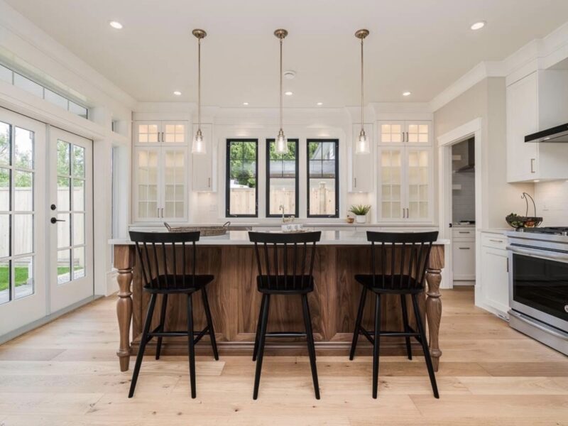 bespoke kitchen design, walnut wood kitchen cabinets, spacious kitchen island, polished quartz countertops, statement pendants light the island, open plan kitchen, countertop glass cabinets, Maxine Whitehead Design