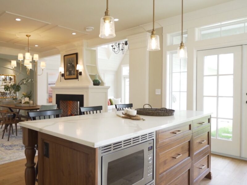 bespoke kitchen design, walnut wood kitchen cabinets, spacious kitchen island, polished quartz countertops, statement pendants light the island, open plan kitchen, Maxine Whitehead Design