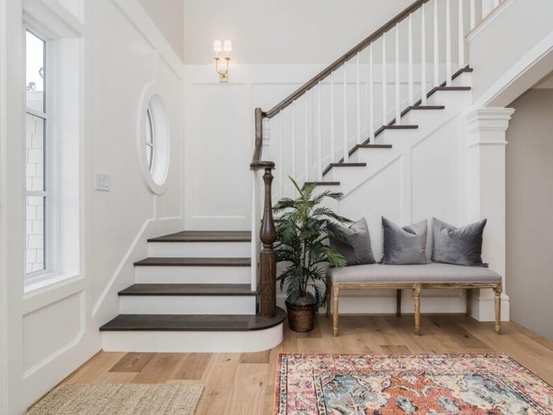 grand staircase, grand entrance, bright airy welcoming entryway, statement rug, timeless style, oval window focal point, Maxine Whitehead design