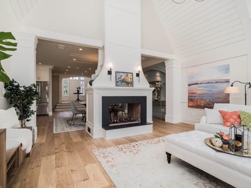 double sided fireplace, vaulted ceiling, grand chandelier, ship lap detail, spacious great room, soaring ceiling, inviting paint palette, clerestory windows, white sofa, Maxine Whitehead design