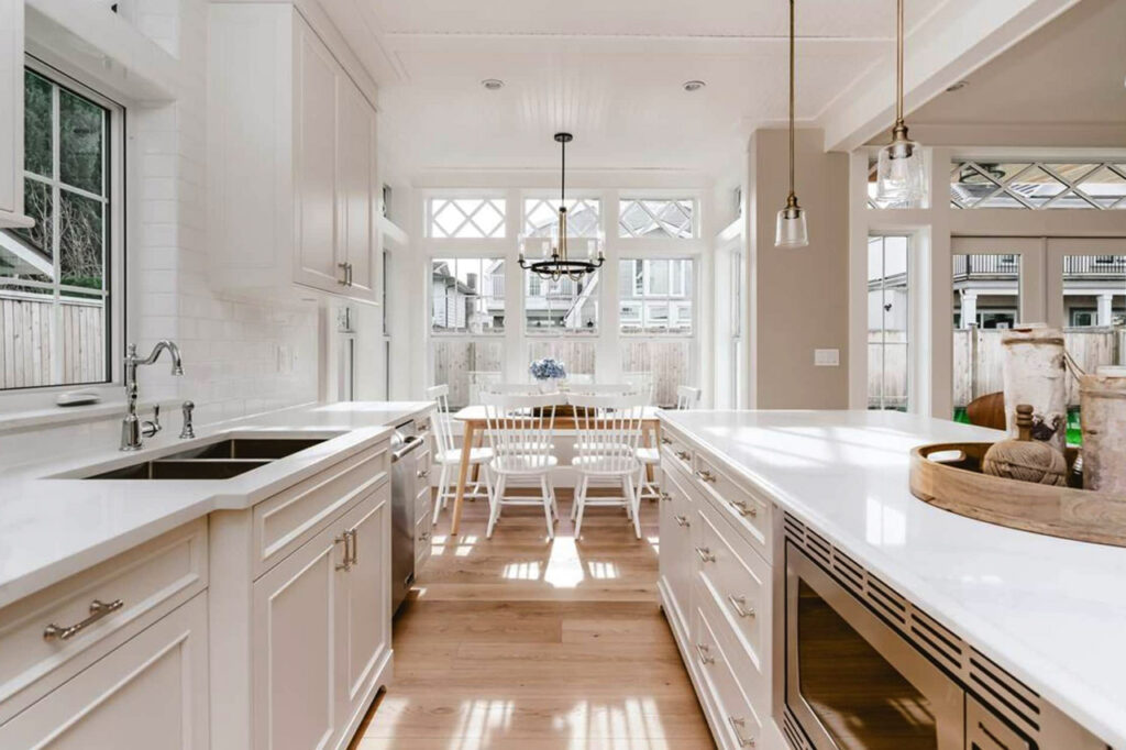 bespoke kitchen design, shaker style kitchen cabinets, timeless white kitchen style, classic white kitchen, spacious kitchen island, polished quartz countertops, statement lighting, Maxine Whitehead Design